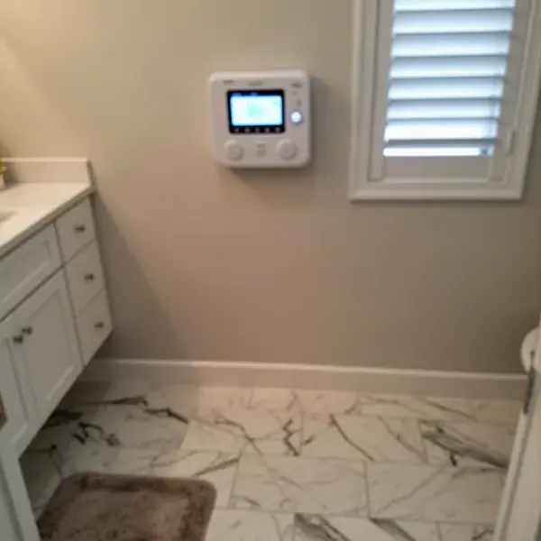 Floor heating thermostat above finished tile in Pukalani bathroom